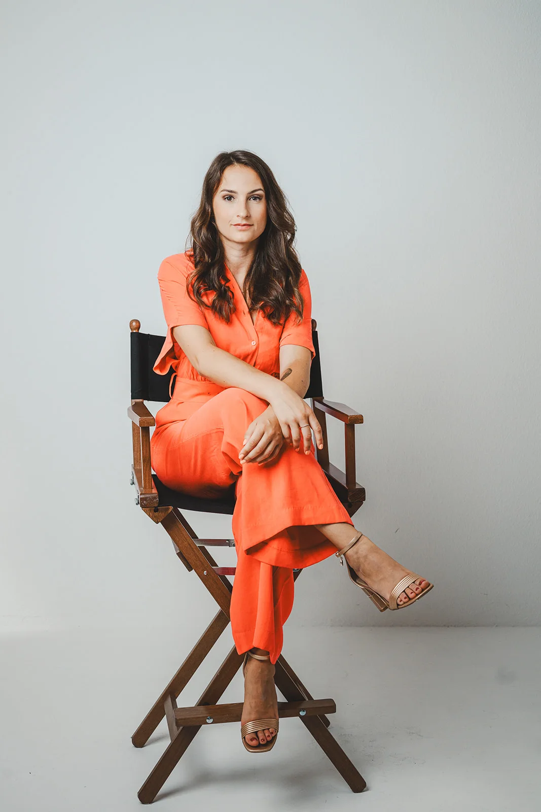 Anzhelika sitting on a chair wearing orange outfit<br />
